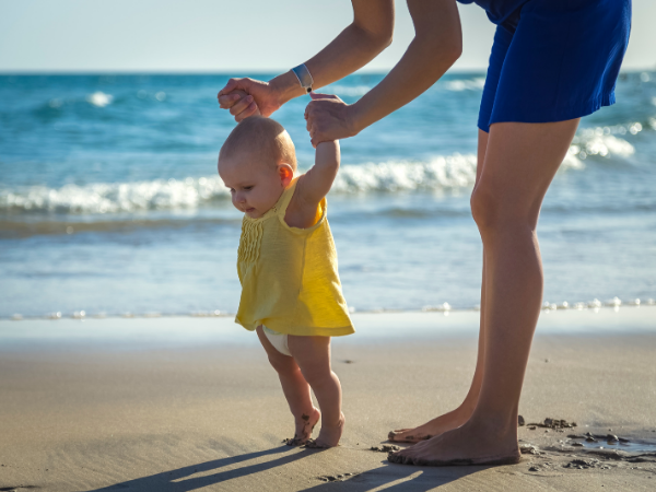 Baby taking first steps with mom